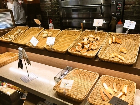 台に乗せられている食べ放題のパンの写真